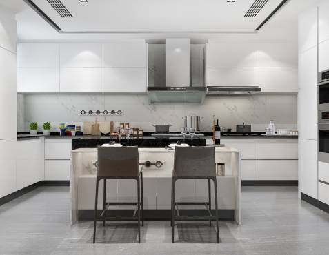 Modern kitchen with white cabinets, a central island with two gray stools, stainless steel appliances, and various cooking items on the countertops.